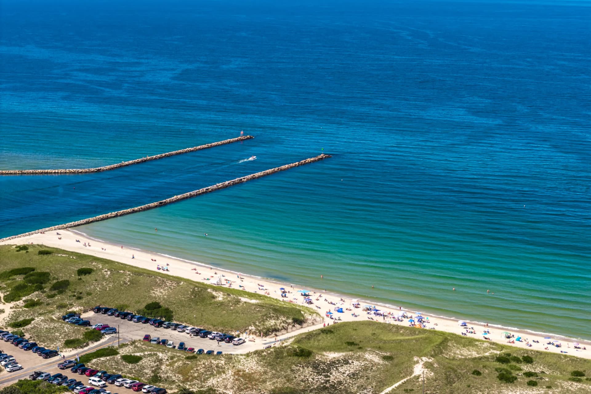 Aerial view of Dennis beach with turquoise water and stone jetties