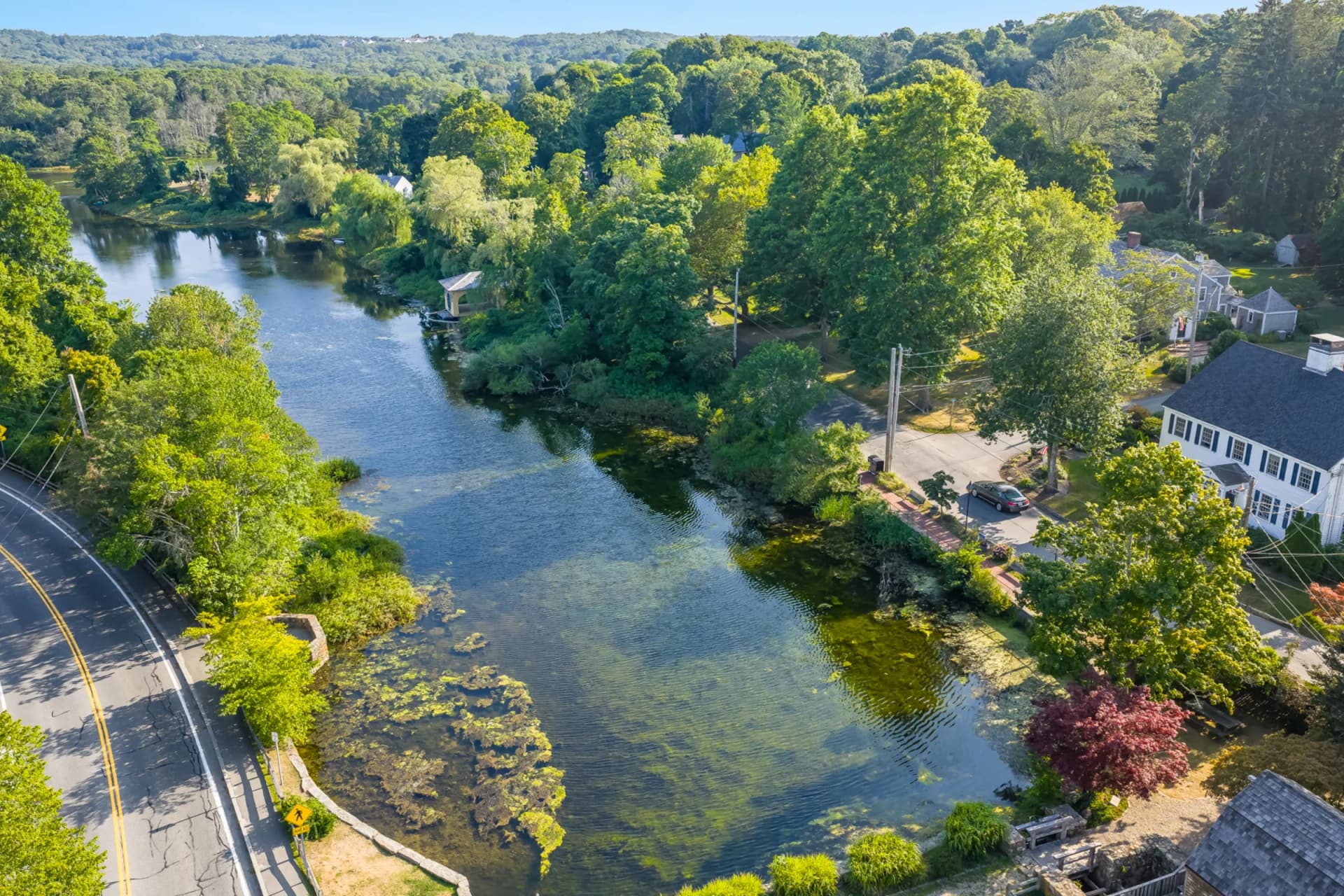 Aerial view of Sandwich creek winding through lush greenery with historic homes